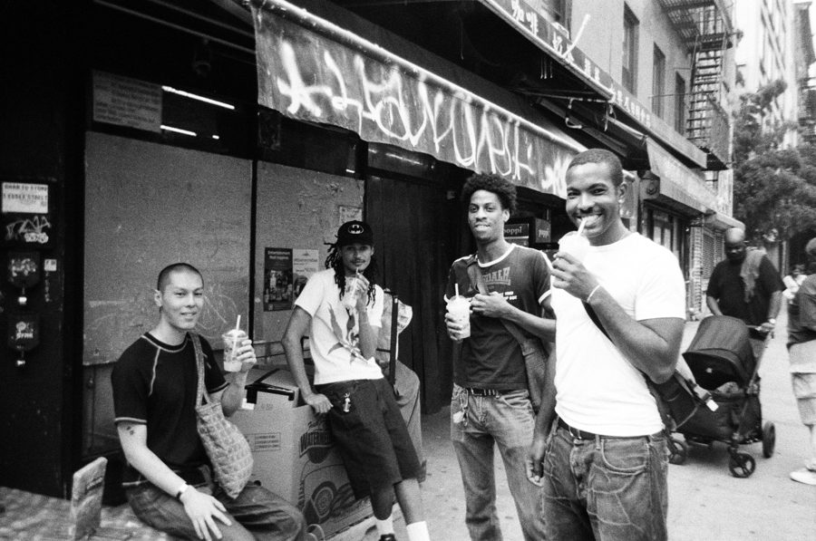 Friends with drinks outside a storefront, black and white film